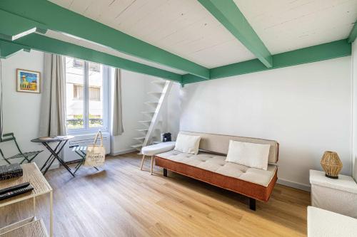 un salon avec un canapé et une table dans l'établissement LE PETIT PALAIS avec mezzanine de charme au cœur de Cannes, à Cannes