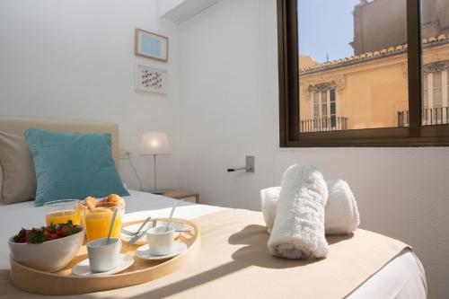a hotel room with a breakfast tray on a bed at Xativa Terrace II in Valencia