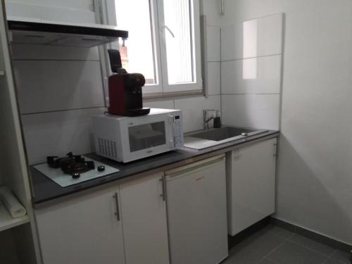 une cuisine avec un micro-ondes et un évier dans l'établissement Studio avec canapé-lit, à Banyuls-sur-Mer
