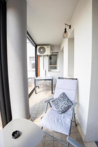 a room with a white chair and a table at Le Ninfee in Zola Predosa