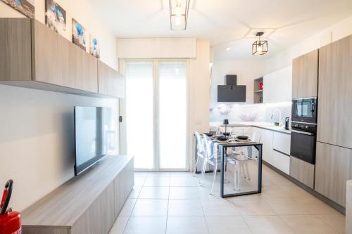 a kitchen with a television and a table with chairs at Le Ninfee in Zola Predosa