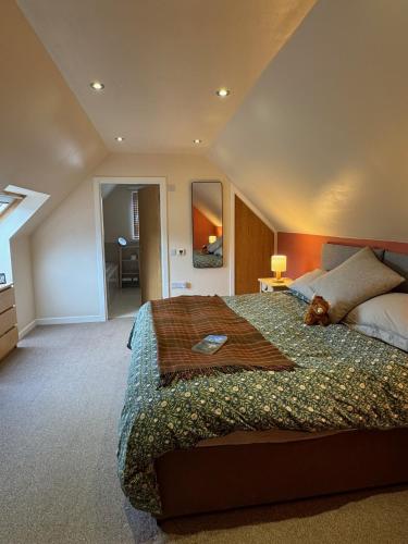 a bedroom with a large bed with a teddy bear on it at Willowbarn Rafford Self Catering in Forres