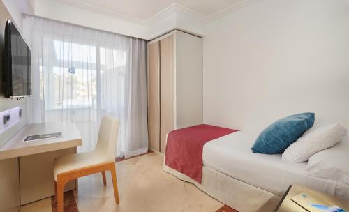 a hotel room with a bed and a desk and a chair at Grupotel Acapulco Playa - Adults Only in Playa de Palma