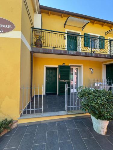 a yellow building with green doors and a balcony at Affittacamere PZ in Vernazza