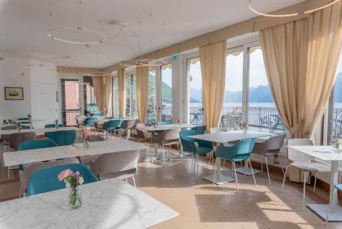 a restaurant with tables and chairs and windows at Casa Du Lac, by R Collection Hotels in Varenna
