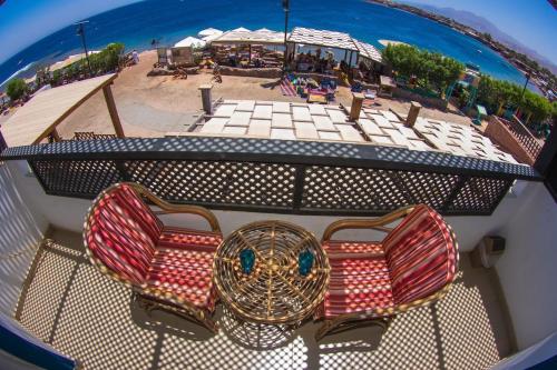Blick auf einen Strand mit 2 Stühlen und einem Tisch in der Unterkunft Dahab Eternal Sea Horizon in Saint. Catherine