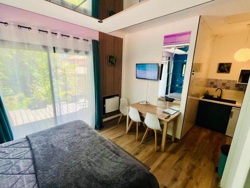 a bedroom with a bed and a desk and a table at Studio chic & champêtre in Aussonne