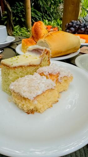 a white plate with two slices of cake on it at Xamã Senses - Hotel Pousada in Pipa