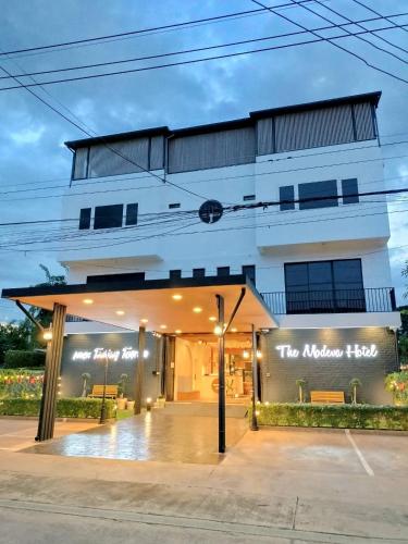 a building with a sign that reads the modern house at The Modeva Hotel in Kanchanaburi