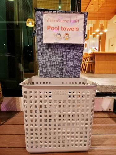 a white basket with a sign on top of it at The Modeva Hotel in Kanchanaburi