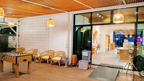 a room with a table and chairs and a room with windows at The Modeva Hotel in Kanchanaburi