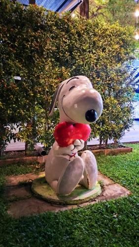 a statue of a dog sitting in the grass at The Modeva Hotel in Kanchanaburi