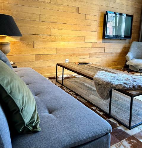 salon z kanapą i stołem w obiekcie La Mer w mieście De Panne