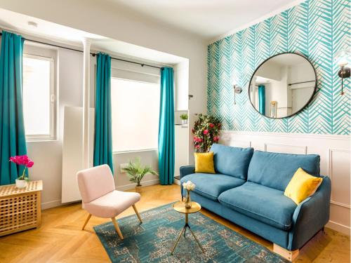 un salon avec un canapé bleu et un miroir dans l'établissement Merveil - Luxury Suite - Champs Elysées - Mermoz, à Paris
