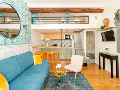 un salon avec un canapé bleu et une cuisine dans l'établissement Merveil - Luxury Suite - Champs Elysées - Mermoz, à Paris