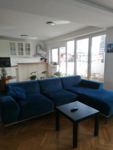 ein Wohnzimmer mit einem blauen Sofa und einem Tisch in der Unterkunft Dijuto Apartment in Skopje