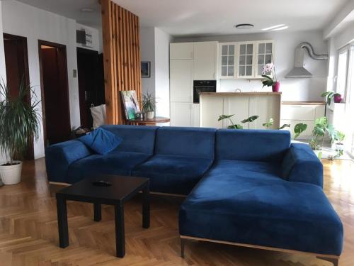 ein Wohnzimmer mit einem blauen Sofa und einem Tisch in der Unterkunft Dijuto Apartment in Skopje
