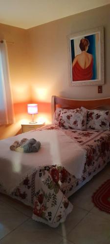 a bedroom with a bed and a painting on the wall at Casa Vintage in Joinville