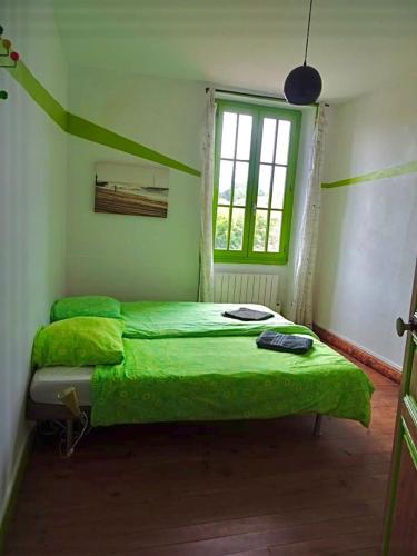 - un lit vert dans une chambre avec fenêtre dans l'établissement h2oholidays, à Capbreton