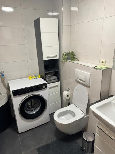 a bathroom with a washing machine and a toilet at Komplett neu renovierte Wohnung! in Hannover