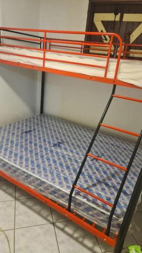 an orange bunk bed with a blue mattress on it at Appartement accueillant à Bouillante de 54 m² in Bouillante
