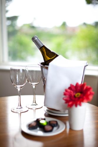 a bottle of wine and two glasses on a table at The Lakeside Hotel & Leisure Centre in Killaloe