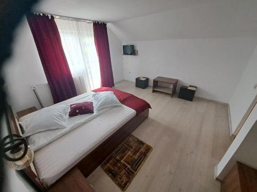 a bedroom with a large bed and a window at Casa Doi Crai in Zărneşti