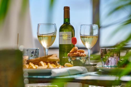 a table with two glasses of white wine and cheese at Grupotel Acapulco Playa - Adults Only in Playa de Palma