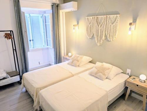 une chambre avec deux lits et une fenêtre dans l'établissement Appartement Mercatu au coeur de Calvi, à Calvi