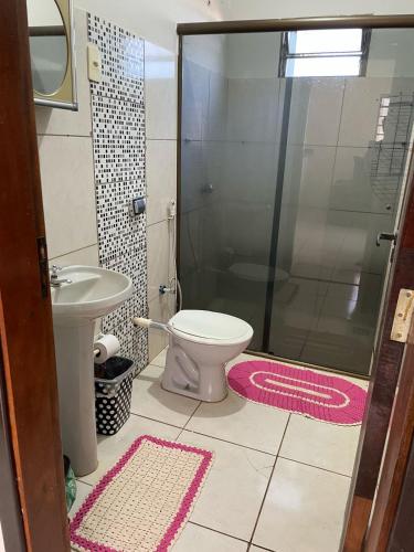 a bathroom with a shower and a toilet and a sink at Sua casa em Dourados in Dourados