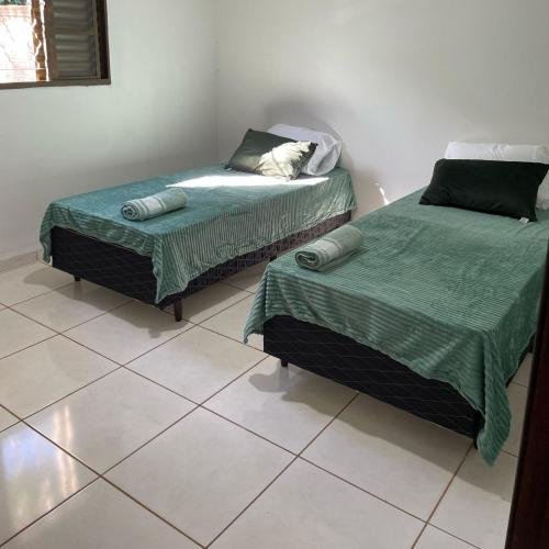 zwei Betten nebeneinander in einem Zimmer in der Unterkunft Sua casa em Dourados in Dourados