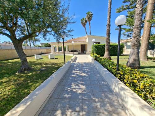 a walkway in a park with palm trees and lights at Villa Carmela Arenella in Arenella
