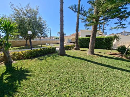 a yard with palm trees and a building at Villa Carmela Arenella in Arenella