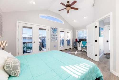 a bedroom with a large bed with a ceiling fan at Steps to Beach Lake-View Laconia Getaway! in Laconia