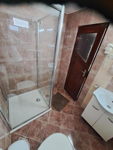 a bathroom with a shower and a toilet and a sink at Casa Doi Crai in Zărneşti