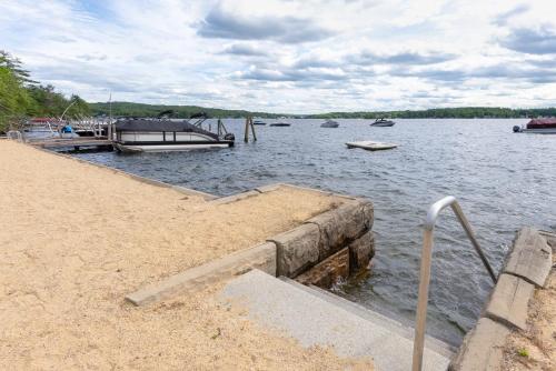 a dock with several boats in the water at Steps to Beach Lake-View Laconia Getaway! in Laconia