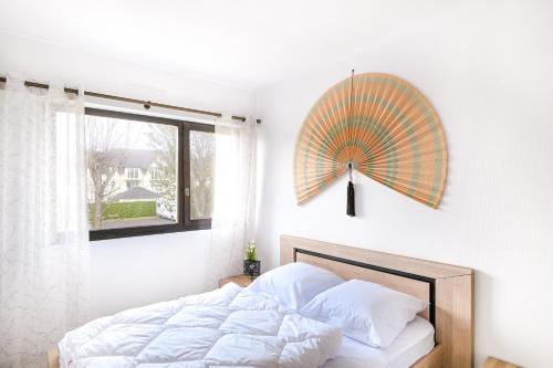 - une chambre avec un lit et un parasol sur le mur dans l'établissement L'Ancre Normande - 7min à pied de la Plage, à Courseulles-sur-Mer