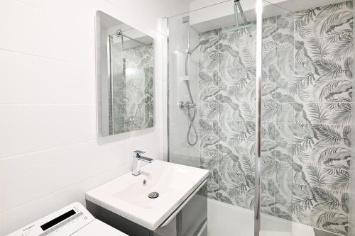 une salle de bain avec un lavabo et une douche dans l'établissement L'Ancre Normande - 7min à pied de la Plage, à Courseulles-sur-Mer