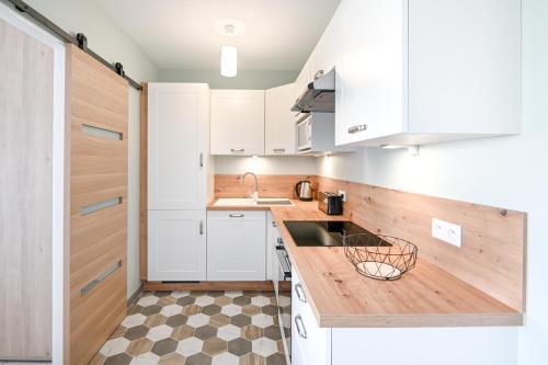 une cuisine avec des armoires blanches et un comptoir en bois dans l'établissement L'Ancre Normande - 7min à pied de la Plage, à Courseulles-sur-Mer