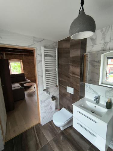 a bathroom with a white sink and a toilet at Apartamenty Stara Cegła in Zgorzelec