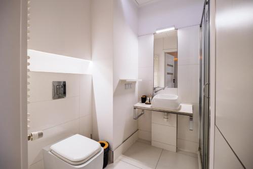 Un baño blanco con inodoro y lavabo. en About Art Apartments - Ovo, en Wroclaw