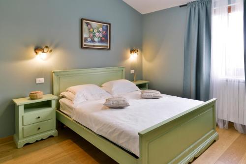 a bedroom with a bed with white sheets and pillows at Villas Vilanija in Umag
