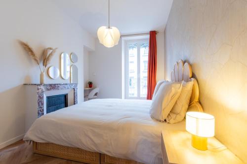 une chambre blanche avec un lit et une cheminée dans l'établissement Le petit Berriat T2, à Grenoble