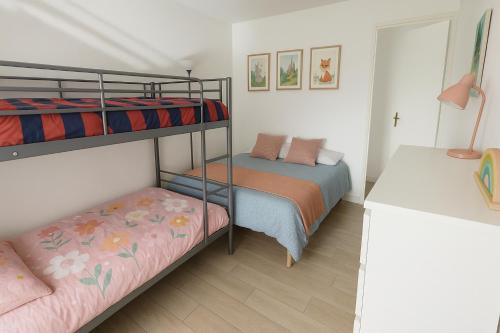 a bedroom with two bunk beds and a desk at Magic Disney Terrasse - 2 ch - parking gratuit - 5 min parc in Serris