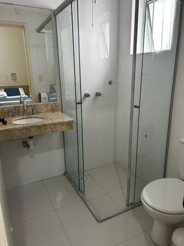a bathroom with a shower and a sink and a toilet at BARLOS HOTEL in Uruguaiana