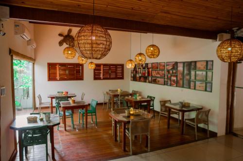 a restaurant with tables and chairs in a room at Xamã Senses - Hotel Pousada in Pipa