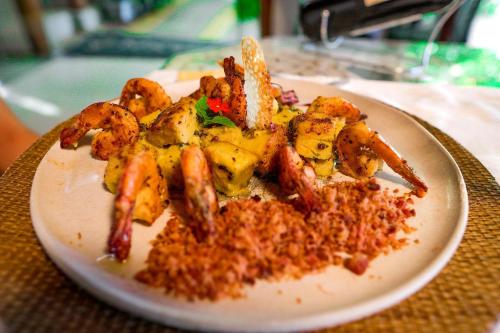 a plate of food with shrimp on a table at Xamã Senses - Hotel Pousada in Pipa