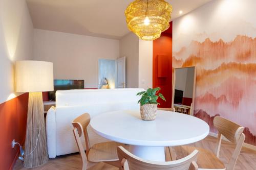 un salon avec une table et des chaises blanches dans l'établissement Le petit Berriat T2, à Grenoble