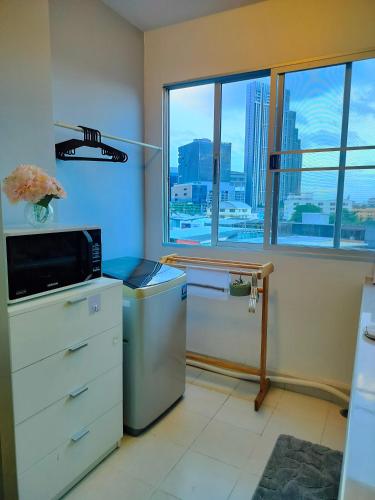 a kitchen with a microwave and a refrigerator and a window at ห้องพักสวยแสนสบาย in Ban Chek