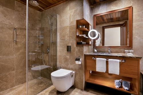 a bathroom with a shower and a toilet and a sink at Kempinski Hotel San Lawrenz in San Lawrenz
